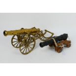 A model canon on wooden carriage and a brass example, largest 42 cm (l). [2].
