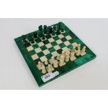 A malachite and hardstone chess set with brass inlay, king approximately 4 cm. [2].