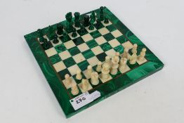 A malachite and hardstone chess set with brass inlay, king approximately 4 cm. [2].