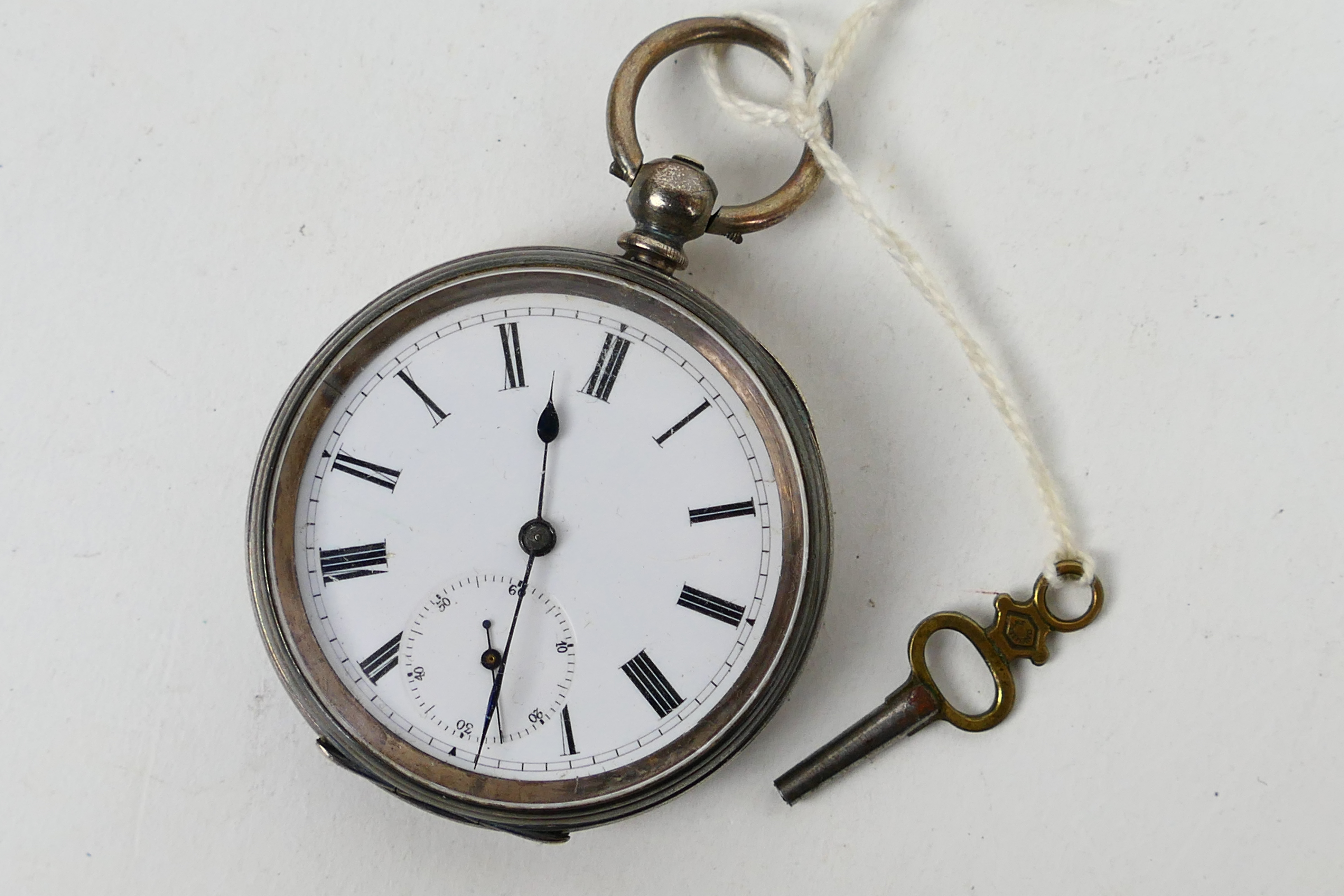 A Swiss silver (935 fineness) cased open face pocket watch, Roman numerals to a white enamel dial,