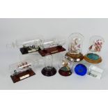 Various decorative ships in bottles, under glass domes, glass Spitfire in sphere and other.
