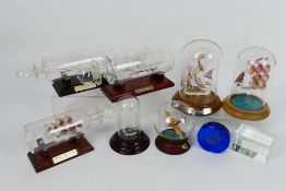 Various decorative ships in bottles, under glass domes, glass Spitfire in sphere and other.