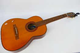 A Tatra Classic de luxe acoustic guitar and tuner.