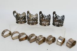 Four Edwardian silver coffee can holders with scrolling floral decoration,