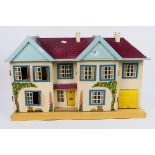 A wooden doll's house with applied floral decals,