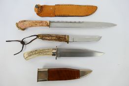 Three knives, each with antler grip, largest with 30.5 cm (l) blade, two contained in sheaths.