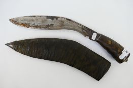 A Gurkha Kukri knife with 30 cm (l) blade, wooden grip and brass bolster, contained in scabbard.