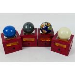 A boxed gemstone terrestrial globe paperweight and three more similar.