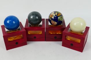 A boxed gemstone terrestrial globe paperweight and three more similar.