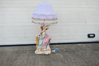 A large figural table lamp depicting a gentleman serenading a lady, approximately 104 cm (h).