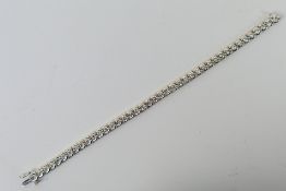 An 18ct white gold Diamond line bracelet containing 41 round brilliant cut diamonds in an open rim