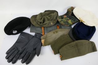 A quantity of military and military style caps, hats and other.