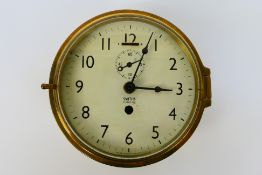 A brass ships clock or bulkhead clock,