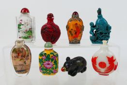 A group of snuff bottles to include glass, ceramic, carved stone and other.