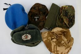 A collection of military and military style caps and hats.