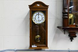 A Comitti Of London wall clock, approximately 58 cm.