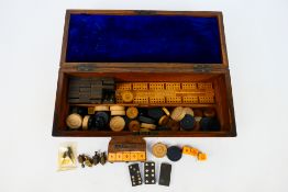 A burr wood veneered games compendium box containing cribbage board, dominoes,