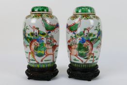 A pair of Chinese covered vases decorated with a warrior and scholar on horseback,