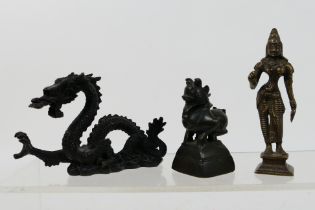 A group of small Asian cast metal figures to include a dragon, Indian deity and similar, largest 10.