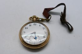 A gold plated open face pocket watch, Arabic numerals to a white enamel dial,