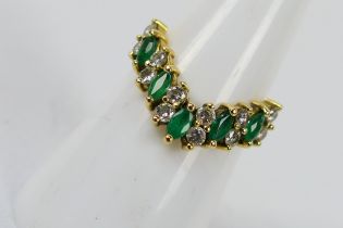 A hallmarked 18ct yellow gold wishbone ring set with five Marquise cut emeralds and twelve round