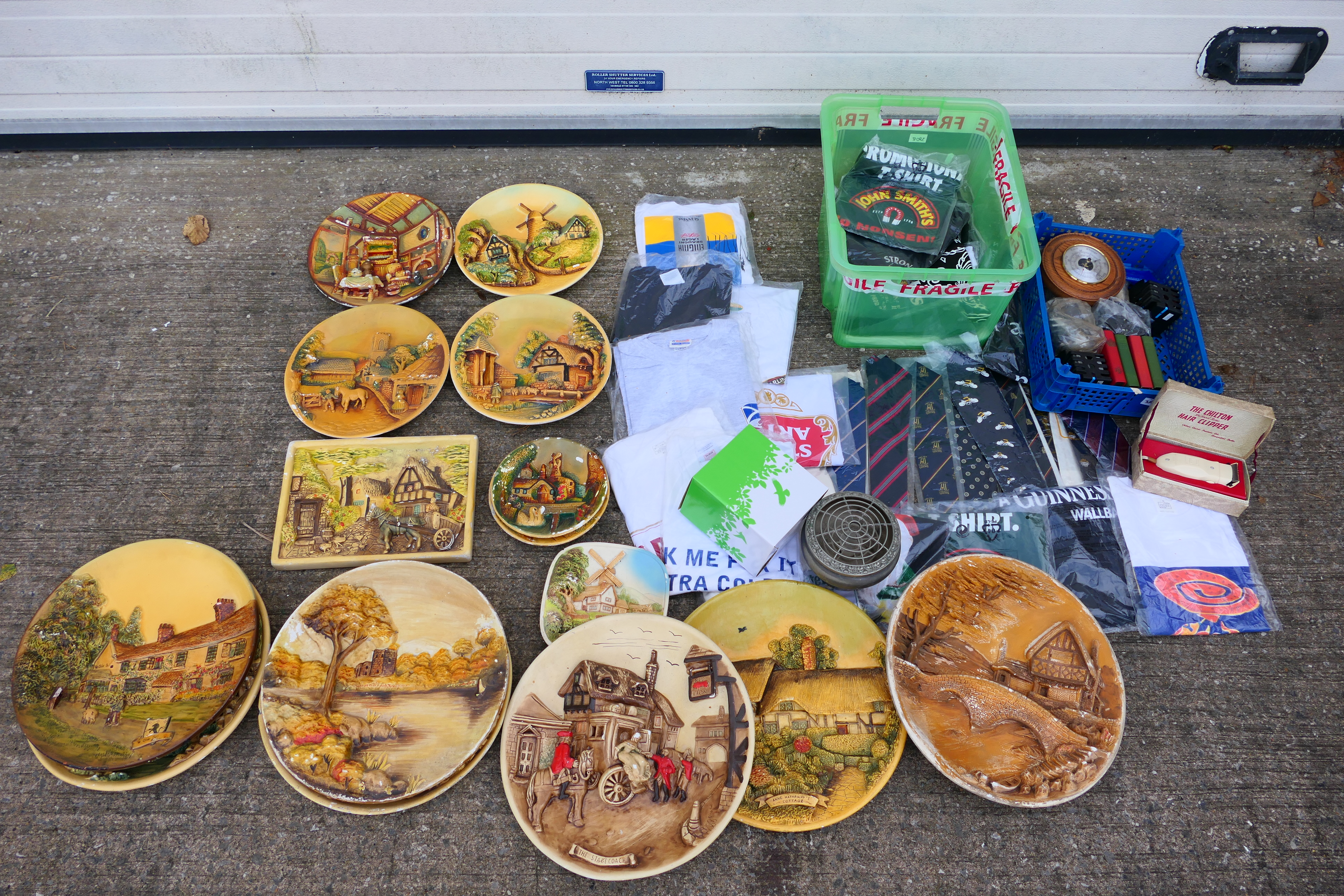 A collection of plaster wall plaques, largest approximately 37 cm (d), a quantity of T shirts,