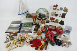 A mixed lot of ornaments, puppets, tea cards and other.