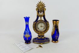A Franklin Mint porcelain cased Marie-Antoinette Clock, cobalt blue and gilt of lyre form,