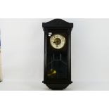 A dark brown wall clock. Wall clock is marked Glocken-Gong. Wall clock comes with key and pendulum.