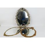 Three decoratively framed, oval wall mirrors, largest approximately 62 cm x 45 cm. [3].