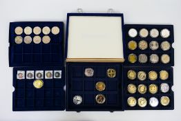 A collection of various commemorative / collector coins in presentation cases / coin tray.