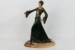 A cold cast Art Deco style figure depicting a stylish young lady, raised on marble base,