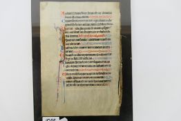 An illuminated manuscript page of Latin text, 20 lines, framed, page approximately 24 cm x 17 cm.