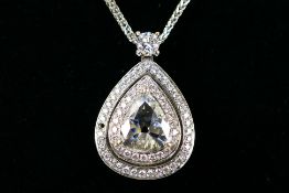 An 18ct white gold Diamond pendant containing a pear shaped Diamond set with two outer rows of