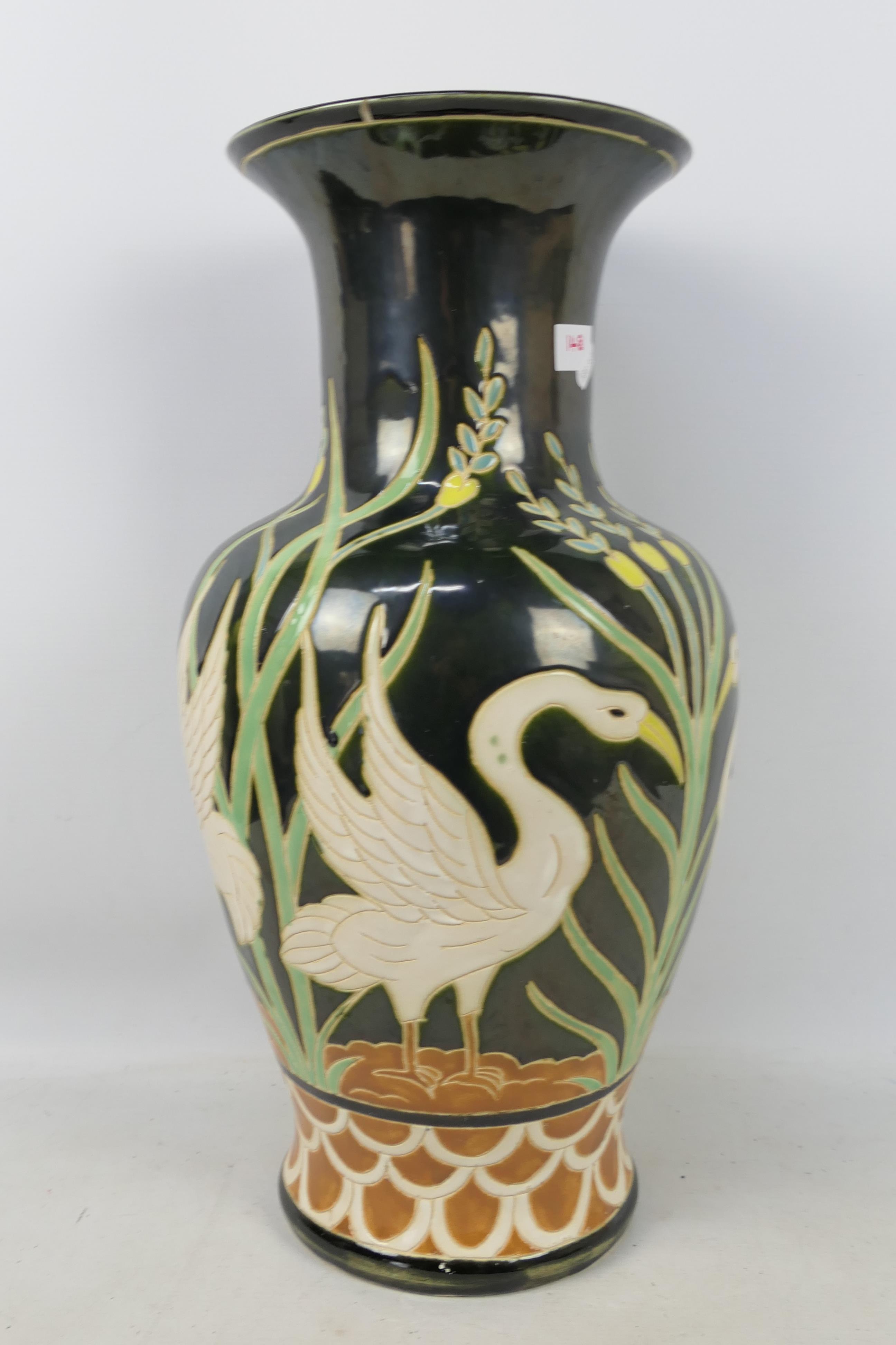 A large baluster vase decorated with swans, approximately 52 cm (h).