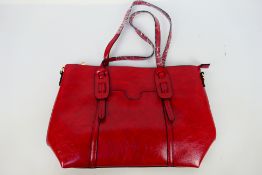 An unmarked red leather handbag with shoulder strap - Bag has two inner zip pockets and two pouches.