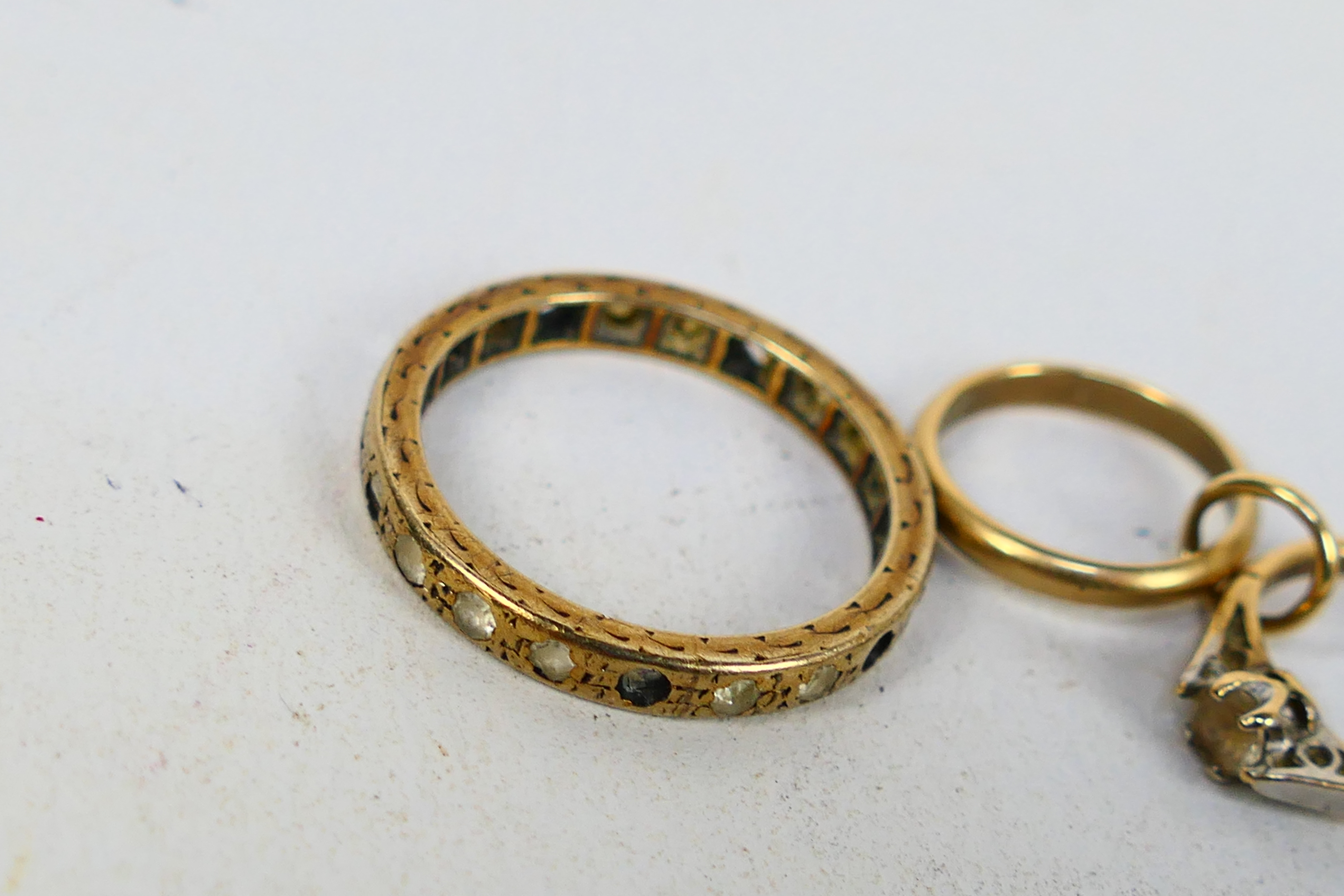 A 9ct gold charm in the form of an engagement and wedding ring and a yellow metal eternity ring - Image 2 of 4