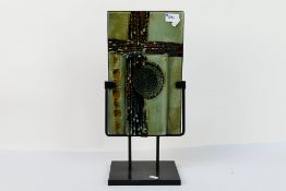 An art glass panel housed in display stand, panel approximately 33 cm x 20 cm.