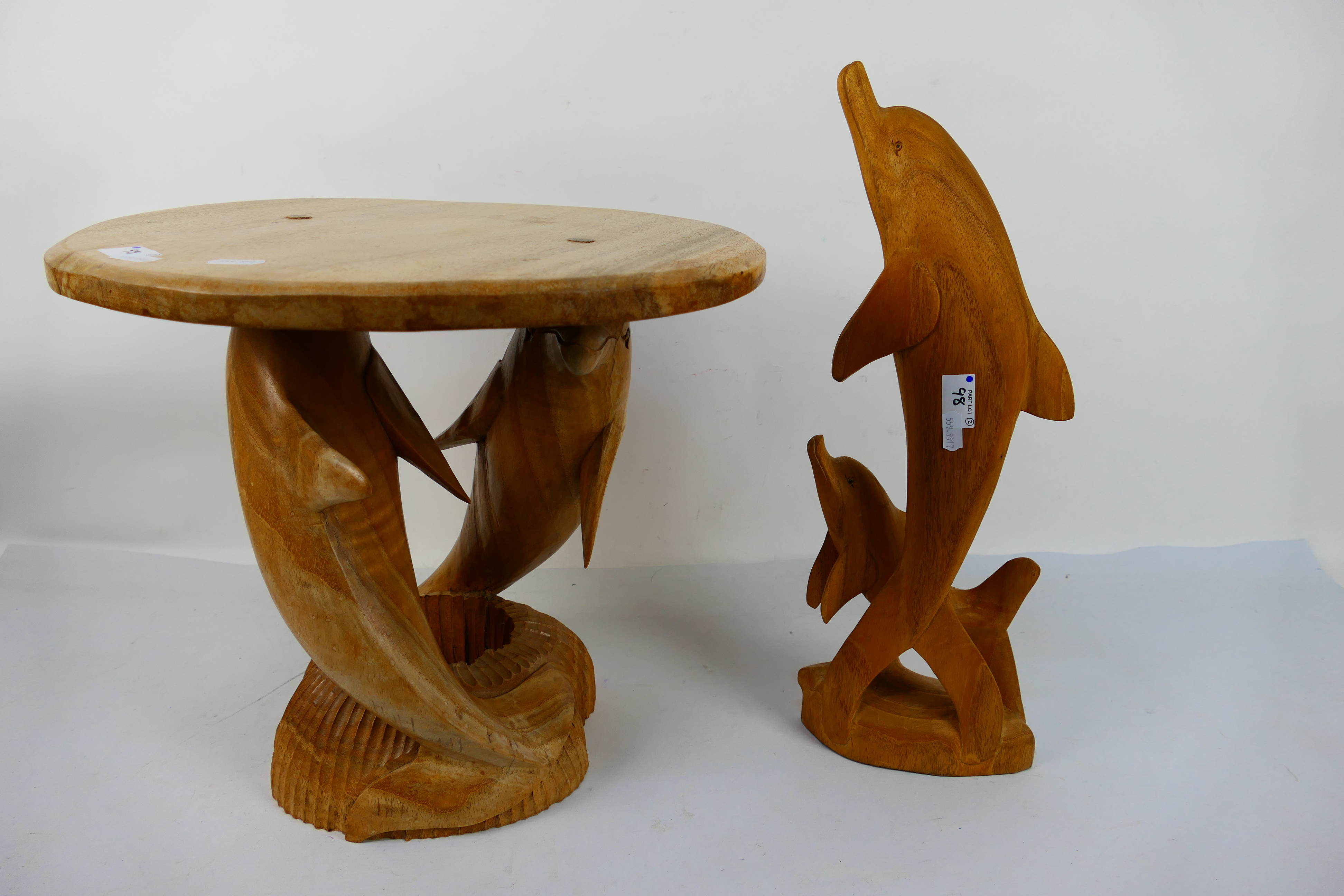 A carved wood occasional table with dolphin supports,