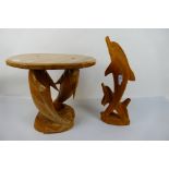 A carved wood occasional table with dolphin supports,