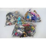 Three clear bags containing a quantity of unsorted costume jewellery, approximately 14 kg.