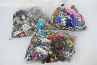 Three clear bags containing a quantity of unsorted costume jewellery, approximately 14 kg.