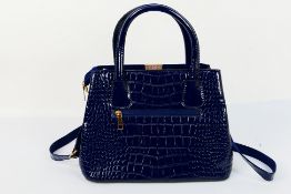 An unmarked dark blue handbag with shoulder strap - Bag has two inner zip pockets, one pouch,