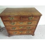 A Georgian chest of two over three drawers with fancy brass drop handles,