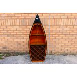 A freestanding bookcase / wine rack in the form of a rowing boat,