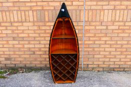 A freestanding bookcase / wine rack in the form of a rowing boat,