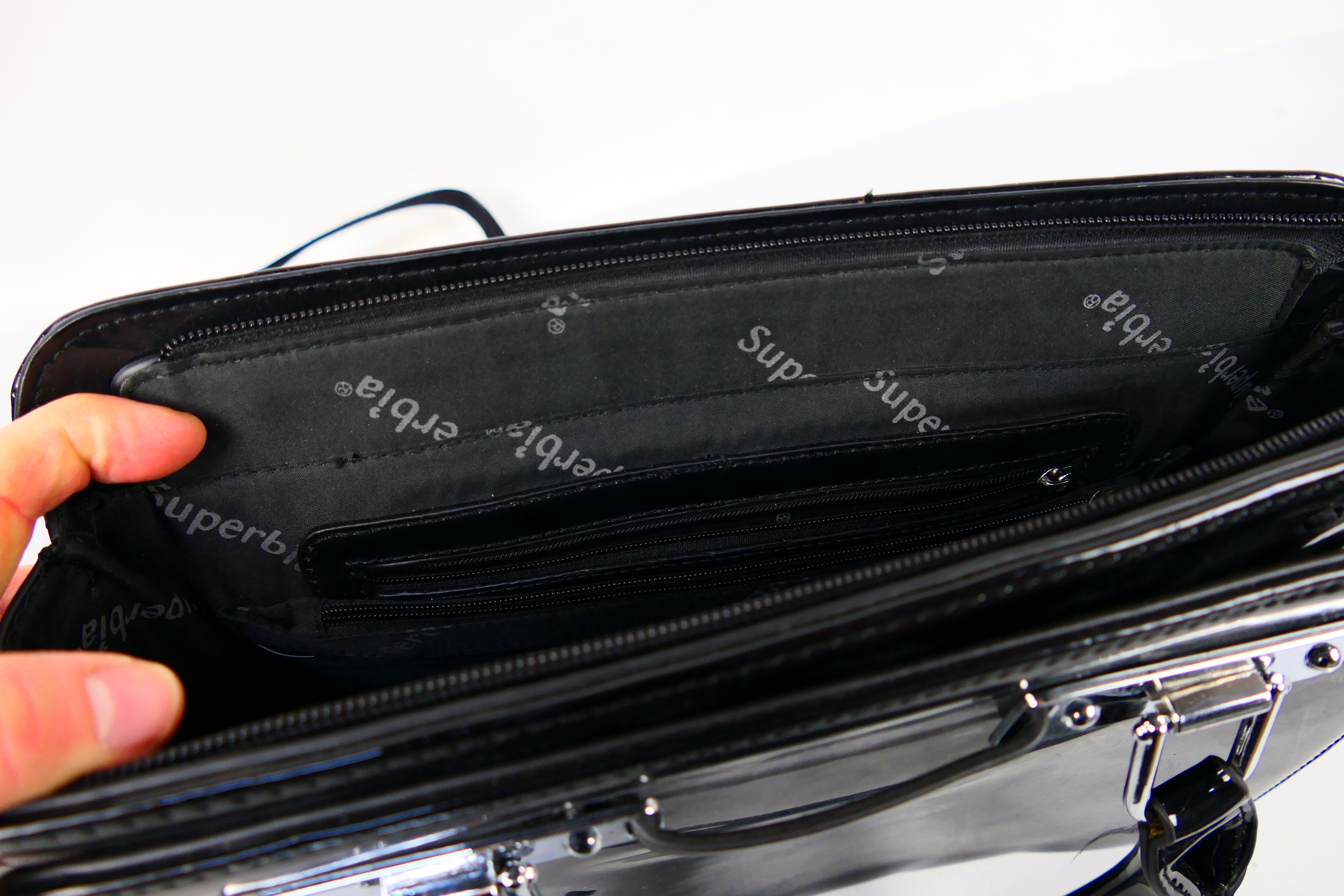 Superbia - A glossy black Superbia handbag with shoulder strap - Handbag has two inside zip pockets, - Image 4 of 4