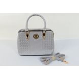 A grey handbag marked M with good quality stitched design and shoulder strap,