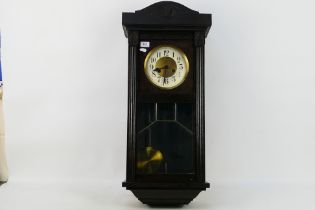 A dark brown wall clock. Wall clock is marked Glocken-Gong. Wall clock comes with key and pendulum.