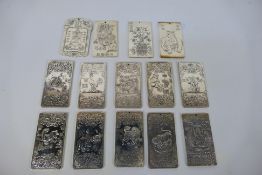 A collection of Chinese white metal trade tokens / plaques, predominantly with zodiac decoration,
